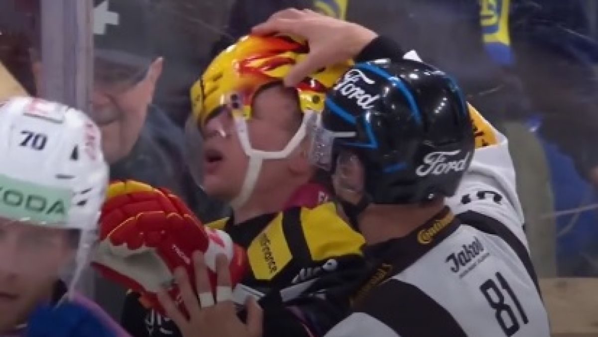 Sędzia poprawia kask Toniego Rajali (EHC Biel) podczas meczu szwajcarskiej National League.